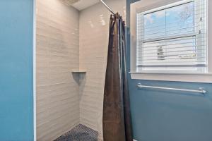 a bathroom with a shower with a shower curtain at Point Judith Coastal Retreat in Narragansett +14 photos