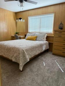 a bedroom with a bed with a ceiling fan and a window at Lakeview Lookout in Tool