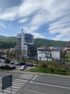a city with a parking lot and a tall building at Central Home in Piatra Neamţ