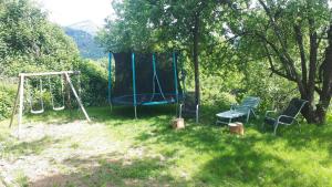 a park with a playground with a swing at Entre Eaux et Roches - Gîte dans maison ardéchoise de caractère in Beaumont +14 photos