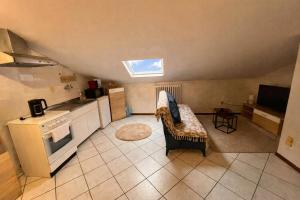 a kitchen with a couch and a stove top oven at Casa LOUES in Asti