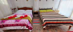 two beds sitting next to each other in a room at Contos de Alice Quartos in Tiradentes