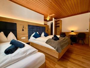 a bedroom with two beds with blue pillows at Pension Lederergütl - Jokercard & Parkplatz inkl in Saalbach-Hinterglemm