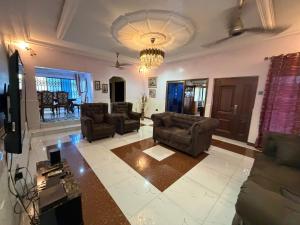 a living room with couches and a chandelier at Afranasa Inn in Tema