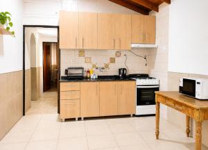 a kitchen with wooden cabinets and a stove at JACARANDA - Alojamiento vacacional in Godoy Cruz