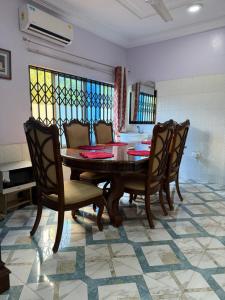 a dining room with a wooden table and chairs at Afranasa Inn in Tema