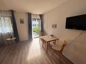 a living room with a table and a flat screen tv at Bergauszeit mit Sauna in Aschau im Chiemgau