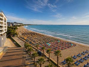 a beach with chairs and umbrellas and the ocean at Sea view apartment 1 in Shëngjin