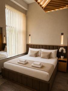 a bedroom with a large bed with two towels on it at Yerevan Resident Hotel in Yerevan