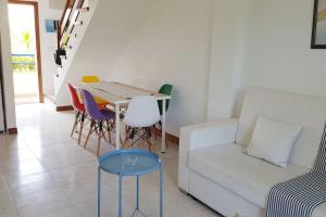 a living room with a couch and a table and chairs at La Arena 4410 in Isla