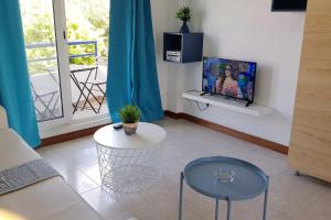 a living room with a couch and a tv and a table at La Arena 4410 in Isla