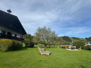 a lawn with a bench in the grass next to a building at Bergauszeit mit Sauna in Aschau im Chiemgau