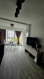 a living room with a television and a living room with a table at Sea View Ani in Olimp