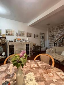 a dining room table with a vase of flowers on it at Be happy in Perast in Perast