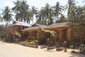 
a beach with palm trees and palm trees at Soe Ko Ko Beach House & Restaurant in Ngwesaung
