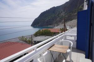 a balcony with a table and a view of the ocean at Gigilos in Agia Roumeli