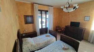 a bedroom with two beds and a chandelier at B&B Gatto Rosso in Sandigliano