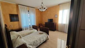 a hotel room with two beds and a television at B&B Gatto Rosso in Sandigliano
