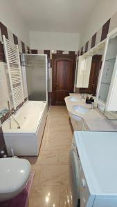 a large bathroom with three sinks and a tub and a tub at B&B Gatto Rosso in Sandigliano