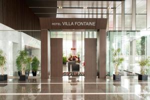 a lobby with potted plants in a building at Hotel Villa Fontaine Grand Tokyo-Tamachi in Tokyo