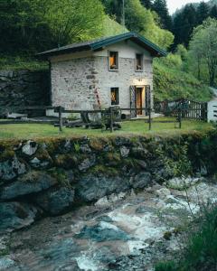 a stone house on the side of a river at ALLA STALLA Suite & Chalet in Piazzatorre
