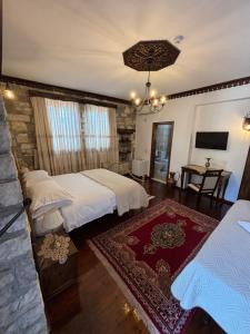 a bedroom with two beds and a stone wall at Boutique Hotel Vila Aleksander in Berat