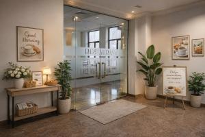 a restaurant lobby with a glass door and potted plants at Yerevan Resident Hotel in Yerevan