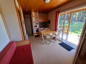 a small kitchen with a table and a balcony at Chalets au bord du lac de Lavalette in Lapte