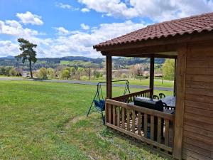 a deck with a gazebo with a grill at Chalets au bord du lac de Lavalette in Lapte