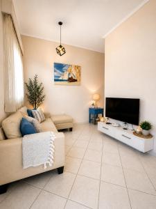 a living room with a couch and a flat screen tv at Villa Joanna in Vasilikos +33 photos