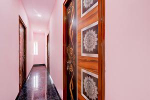 a hallway with a wooden door with paintings on the wall at Hotel O KSR GRAND in Maula Ali