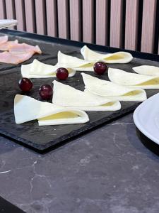 a black tray with cheese and grapes on a table at Hotel Alain by Dynamic Hotels in Silla +45 photos
