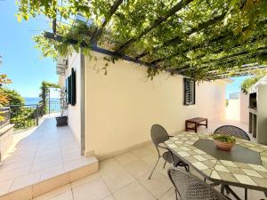 a patio with a table and chairs on a balcony at Villa Vedran in Podgora
