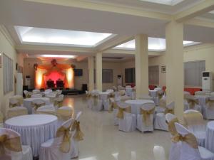 a banquet hall with white tables and chairs and a fireplace at The International Centre Goa in Panaji +32 photos