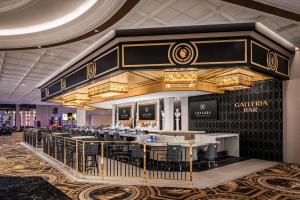 a restaurant with a bar with tables and chairs at Caesars New Orleans, A Caesars Rewards Destination in New Orleans