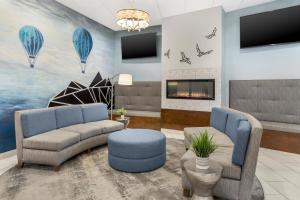 a living room with two couches and a painting of hot air balloons at Best Western Plus Wausau Tower Inn in Wausau