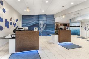 an office with two reception desks and a large painting on the wall at Best Western Plus Wausau Tower Inn in Wausau