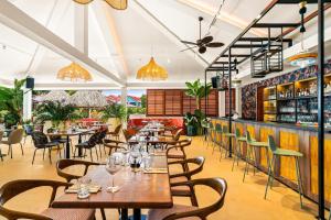 a restaurant with tables and chairs and a bar at Sonesta Hotels & Resorts Livingstone Curacao in Willemstad