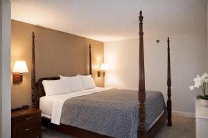 a hotel room with a bed with white pillows at Americas Best Value Inn Raleigh in Raleigh