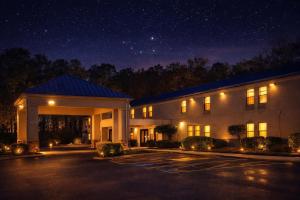 a large building with a parking lot at night at Americas Best Value Inn Raleigh in Raleigh