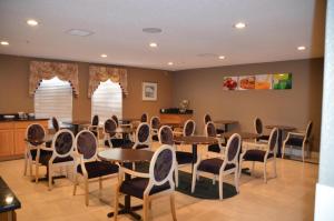 a dining room with tables and chairs and two windows at Americas Best Value Inn Raleigh in Raleigh