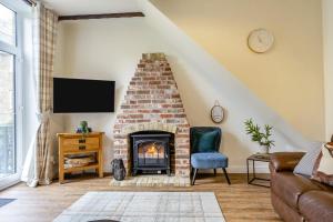 a living room with a brick fireplace and a tv at 2 Bed in Shanklin oc-c36037 in Shanklin