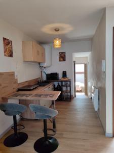 a kitchen with a counter and two bar stools at La Mansarde étoilée in Saint-Marcellin
