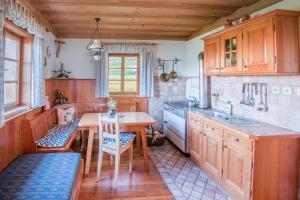 a kitchen with wooden cabinets and a table and chairs at Riggeralm in Rangersdorf