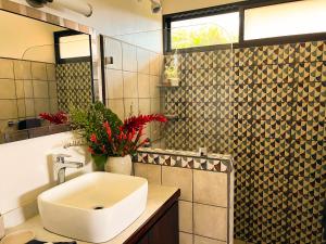 a bathroom with a white sink and a mirror at Luxury In The Jungle in Barú