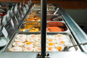 a buffet line of food with eggs and other foods at Hotel Podostrog - New Comfort 2026 in Budva