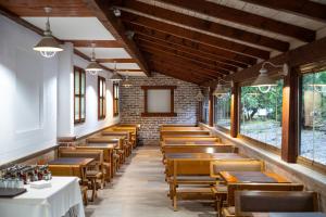 a row of tables and chairs in a room with windows at Hotel Podostrog - New Comfort 2026 in Budva