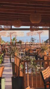 a patio with tables and potted plants and umbrellas at Karos Hotel Llaman in Himare