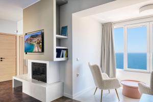 a living room with a fireplace and a window at Apollo Romantic Sea View Villa in Kiveri