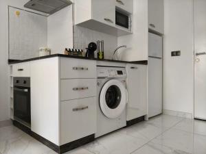 a white kitchen with a washing machine in it at Apartamentos Dali 1 in Guadix